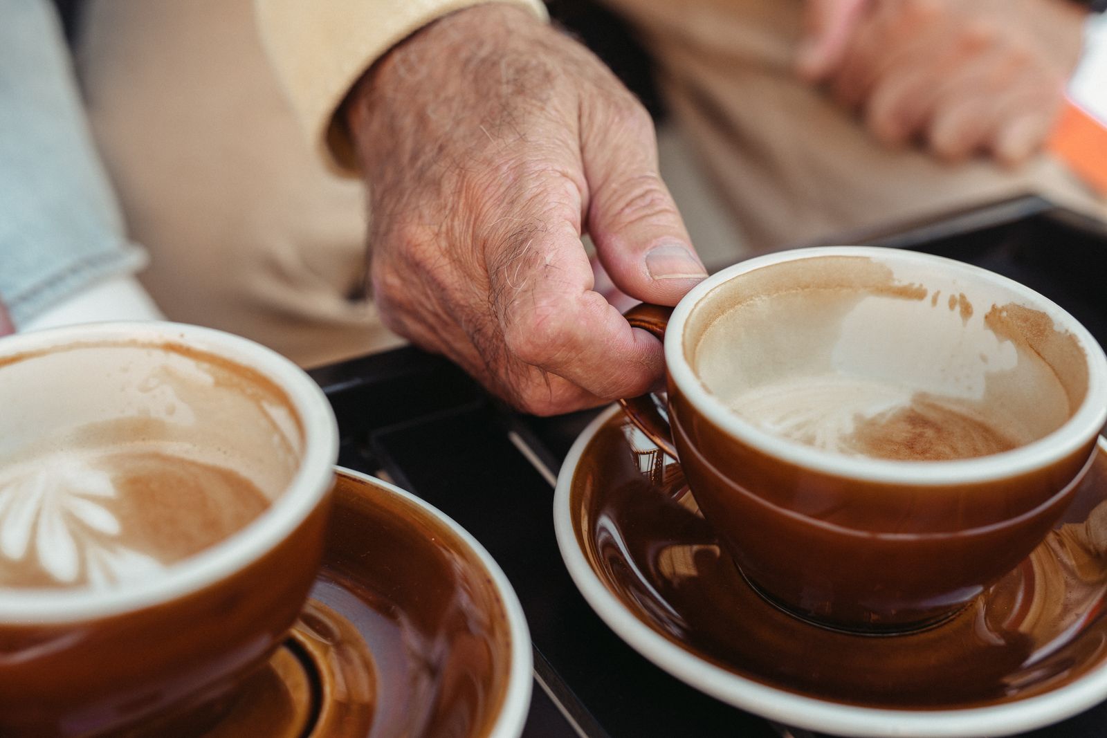 Hände an Kaffeetassen als Zeichen für Unterstützung und Entlastung